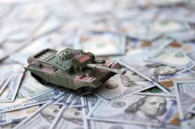 100 dolarlık banknotlardaki oyuncak tankları kapatın. Savaş maliyetleri, askeri harcamalar ve ekonomik kriz kavramı