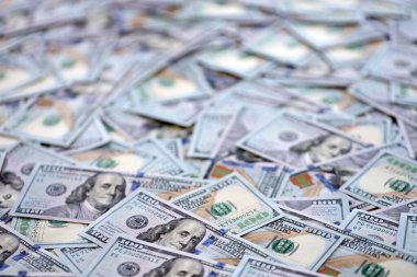 Çok büyük miktarlarda 100 dolarlık banknotlar kapanıyor. Düz tablonun üzerinde büyük miktarda Birleşik Devletler para birimi notu var.
