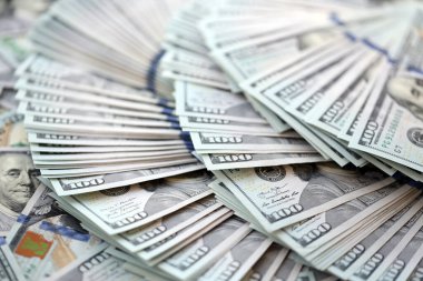 Çok büyük miktarlarda 100 dolarlık banknotlar kapanıyor. Düz tablonun üzerinde büyük miktarda Birleşik Devletler para birimi notu var.