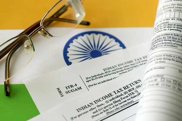 Indian income tax return blank form with pen and indian rupees bills on indian country flag close up. Annual tax report concept