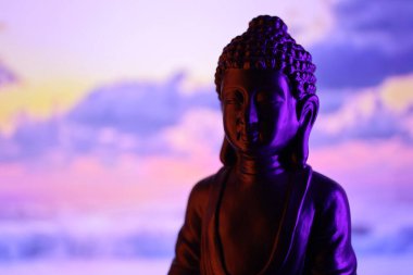 Buddha Purnima ve Vesak Günü konsepti, güzel ve renkli arka plana karşı yumuşak ışık saçan Buda heykeli. Meditasyon