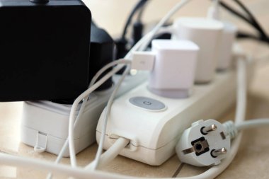 Aşırı yüklenmiş güç panoları. Beyaz zeminde farklı elektrik prizleri olan elektrik şeritleri. Risk tehlikesi kavramı elektrik akımını aşırı yükledi