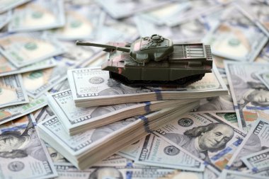 100 dolarlık banknotlardaki oyuncak tankları kapatın. Savaş maliyetleri, askeri harcamalar ve ekonomik kriz kavramı