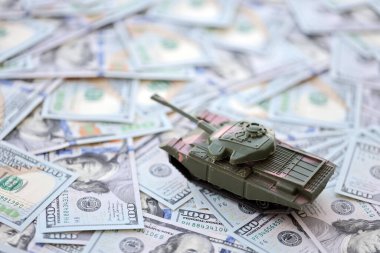 100 dolarlık banknotlardaki oyuncak tankları kapatın. Savaş maliyetleri, askeri harcamalar ve ekonomik kriz kavramı