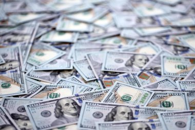 Çok büyük miktarlarda 100 dolarlık banknotlar kapanıyor. Düz tablonun üzerinde büyük miktarda Birleşik Devletler para birimi notu var.