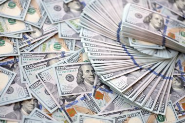 Çok büyük miktarlarda 100 dolarlık banknotlar kapanıyor. Düz tablonun üzerinde büyük miktarda Birleşik Devletler para birimi notu var.