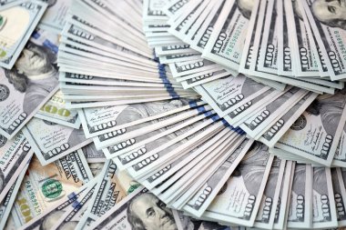 Çok büyük miktarlarda 100 dolarlık banknotlar kapanıyor. Düz tablonun üzerinde büyük miktarda Birleşik Devletler para birimi notu var.