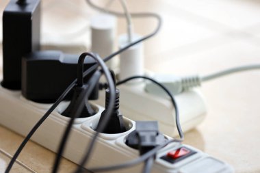 Aşırı yüklenmiş güç panoları. Beyaz zeminde farklı elektrik prizleri olan elektrik şeritleri. Risk tehlikesi kavramı elektrik akımını aşırı yükledi