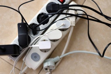 Aşırı yüklenmiş güç panoları. Beyaz zeminde farklı elektrik prizleri olan elektrik şeritleri. Risk tehlikesi kavramı elektrik akımını aşırı yükledi