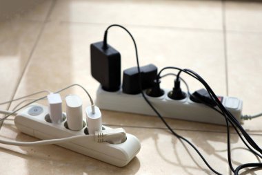Aşırı yüklenmiş güç panoları. Beyaz zeminde farklı elektrik prizleri olan elektrik şeritleri. Risk tehlikesi kavramı elektrik akımını aşırı yükledi