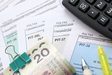 Kazanılan gelir veya zarar miktarının beyanı, PIT-36, PIT-36L, PIT-37 ve PIT-38 vergi formları muhasebeci masasında kalem ve cilalı zloti para faturalarıyla kapatıldı