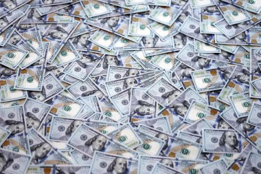 Çok büyük miktarlarda 100 dolarlık banknotlar kapanıyor. Düz tablonun üzerinde büyük miktarda Birleşik Devletler para birimi notu var.