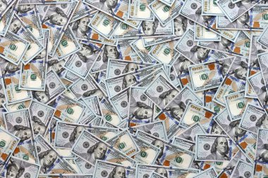 Çok büyük miktarlarda 100 dolarlık banknotlar kapanıyor. Düz tablonun üzerinde büyük miktarda Birleşik Devletler para birimi notu var.