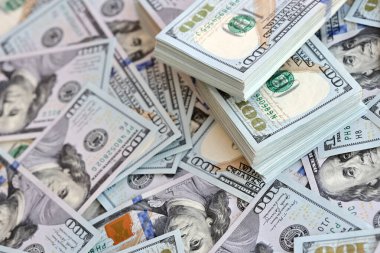 Çok büyük miktarlarda 100 dolarlık banknotlar kapanıyor. Düz tablonun üzerinde büyük miktarda Birleşik Devletler para birimi notu var.