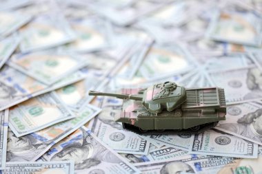 100 dolarlık banknotlardaki oyuncak tankları kapatın. Savaş maliyetleri, askeri harcamalar ve ekonomik kriz kavramı