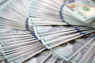 Çok büyük miktarlarda 100 dolarlık banknotlar kapanıyor. Düz tablonun üzerinde büyük miktarda Birleşik Devletler para birimi notu var.