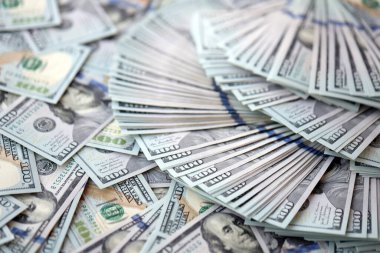 Çok büyük miktarlarda 100 dolarlık banknotlar kapanıyor. Düz tablonun üzerinde büyük miktarda Birleşik Devletler para birimi notu var.