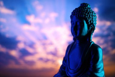 Buddha Purnima ve Vesak Günü konsepti, güzel ve renkli arka plana karşı yumuşak ışık saçan Buda heykeli. Meditasyon