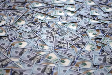 Çok büyük miktarlarda 100 dolarlık banknotlar kapanıyor. Düz tablonun üzerinde büyük miktarda Birleşik Devletler para birimi notu var.