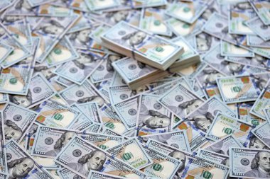 Çok büyük miktarlarda 100 dolarlık banknotlar kapanıyor. Düz tablonun üzerinde büyük miktarda Birleşik Devletler para birimi notu var.
