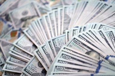 Çok büyük miktarlarda 100 dolarlık banknotlar kapanıyor. Düz tablonun üzerinde büyük miktarda Birleşik Devletler para birimi notu var.