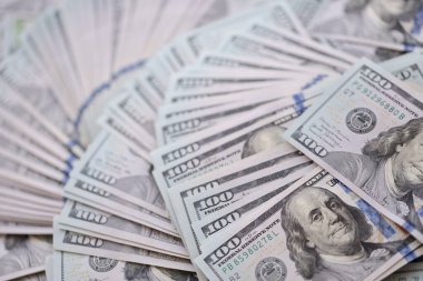Çok büyük miktarlarda 100 dolarlık banknotlar kapanıyor. Düz tablonun üzerinde büyük miktarda Birleşik Devletler para birimi notu var.