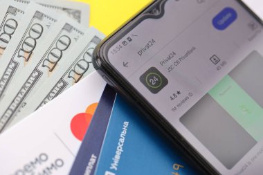 TERNOPİL, UKRAINE - 7 Temmuz 2023 Privatbank yeni bankacılık kartları ve masada para. Privat24 başvurusu kapat
