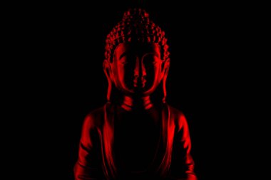 Buddha Purnima ve Vesak Günü konsepti, Kırmızı Buda heykeli, koyu siyah arka plana karşı alçak ışık altında yakın plan. Meditasyon