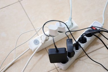 Aşırı yüklenmiş güç panoları. Beyaz zeminde farklı elektrik prizleri olan elektrik şeritleri. Risk tehlikesi kavramı elektrik akımını aşırı yükledi
