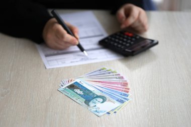 Muhasebeci ofis masasındaki İran vergi formunu doldurmaya başladı. İran 'da vergilendirme dönemi ve yıllık vergi mükellefleri rutini