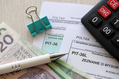 Kazanılan gelir veya zarar miktarının beyanı, PIT-36 ve PIT-36L vergi formları muhasebeci masasında kalem ve Polonya 'nın zloti para faturalarıyla kapanır