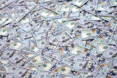Çok büyük miktarlarda 100 dolarlık banknotlar kapanıyor. Düz tablonun üzerinde büyük miktarda Birleşik Devletler para birimi notu var.