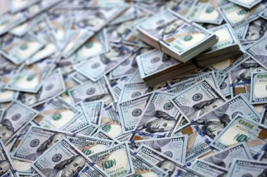 Çok büyük miktarlarda 100 dolarlık banknotlar kapanıyor. Düz tablonun üzerinde büyük miktarda Birleşik Devletler para birimi notu var.