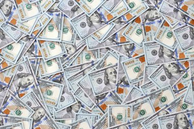 Çok büyük miktarlarda 100 dolarlık banknotlar kapanıyor. Düz tablonun üzerinde büyük miktarda Birleşik Devletler para birimi notu var.