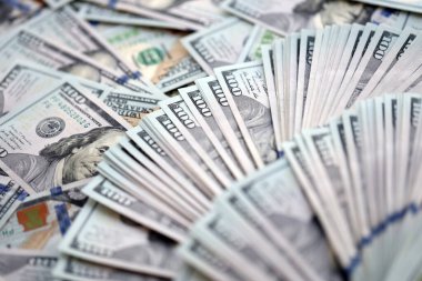 Çok büyük miktarlarda 100 dolarlık banknotlar kapanıyor. Düz tablonun üzerinde büyük miktarda Birleşik Devletler para birimi notu var.