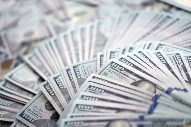 Çok büyük miktarlarda 100 dolarlık banknotlar kapanıyor. Düz tablonun üzerinde büyük miktarda Birleşik Devletler para birimi notu var.