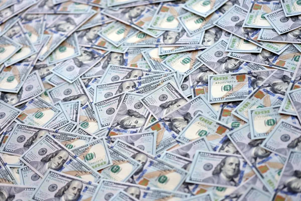 Çok büyük miktarlarda 100 dolarlık banknotlar kapanıyor. Düz tablonun üzerinde büyük miktarda Birleşik Devletler para birimi notu var.