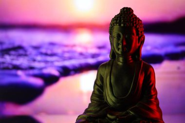 Buddha Purnima ve Vesak Günü konsepti, güzel ve renkli arka plana karşı yumuşak ışık saçan Buda heykeli. Meditasyon