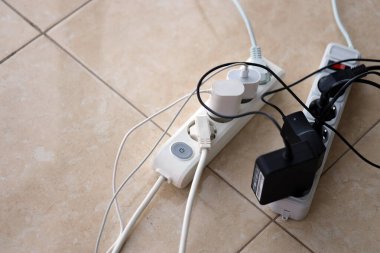 Aşırı yüklenmiş güç panoları. Beyaz zeminde farklı elektrik prizleri olan elektrik şeritleri. Risk tehlikesi kavramı elektrik akımını aşırı yükledi