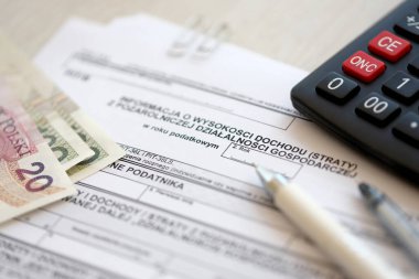 Tarım dışı ekonomik faaliyetlerin gelir veya kaybı hakkında bilgi, tükenmez kalem ve zloti paraları ile muhasebeci masasında PIT-B formu