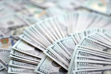 Çok büyük miktarlarda 100 dolarlık banknotlar kapanıyor. Düz tablonun üzerinde büyük miktarda Birleşik Devletler para birimi notu var.