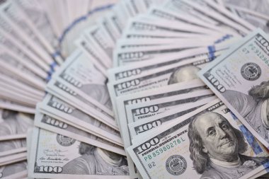 Çok büyük miktarlarda 100 dolarlık banknotlar kapanıyor. Düz tablonun üzerinde büyük miktarda Birleşik Devletler para birimi notu var.