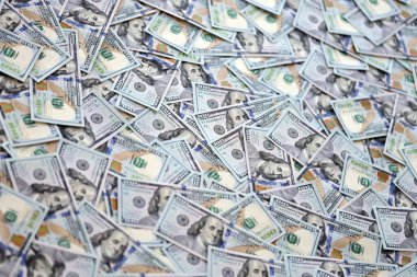 Çok büyük miktarlarda 100 dolarlık banknotlar kapanıyor. Düz tablonun üzerinde büyük miktarda Birleşik Devletler para birimi notu var.