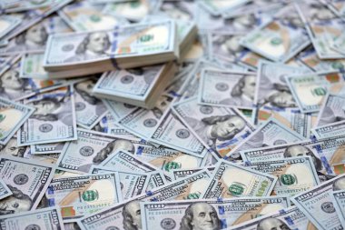 Çok büyük miktarlarda 100 dolarlık banknotlar kapanıyor. Düz tablonun üzerinde büyük miktarda Birleşik Devletler para birimi notu var.