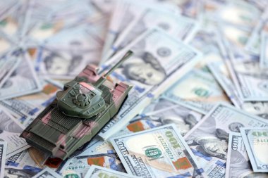 100 dolarlık banknotlardaki oyuncak tankları kapatın. Savaş maliyetleri, askeri harcamalar ve ekonomik kriz kavramı