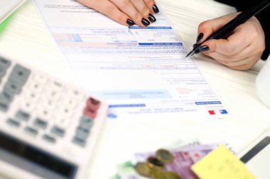KYIV, UKRAINE - 31 Ekim 2023 Muhasebeci Fransız vergi formunu doldurdu 10963 Değer katma vergisi ve vergi döneminin sonunda benzer vergiler. Fransa 'da vergilendirme ve evrak işleri