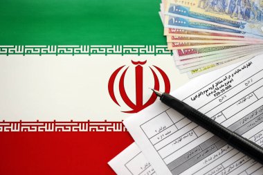 İran 'ın yıllık gelir vergisi iade formu F20-25-006. Masayı kalem ve İran parasıyla doldurmaya hazır.