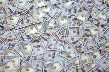 Çok büyük miktarlarda 100 dolarlık banknotlar kapanıyor. Düz tablonun üzerinde büyük miktarda Birleşik Devletler para birimi notu var.