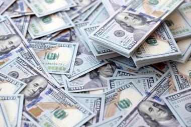 Çok büyük miktarlarda 100 dolarlık banknotlar kapanıyor. Düz tablonun üzerinde büyük miktarda Birleşik Devletler para birimi notu var.