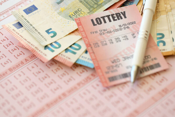 Лотерейный билет и игорный чек на столе с ручкой и банкнотами евро Европейского Союза закрываются